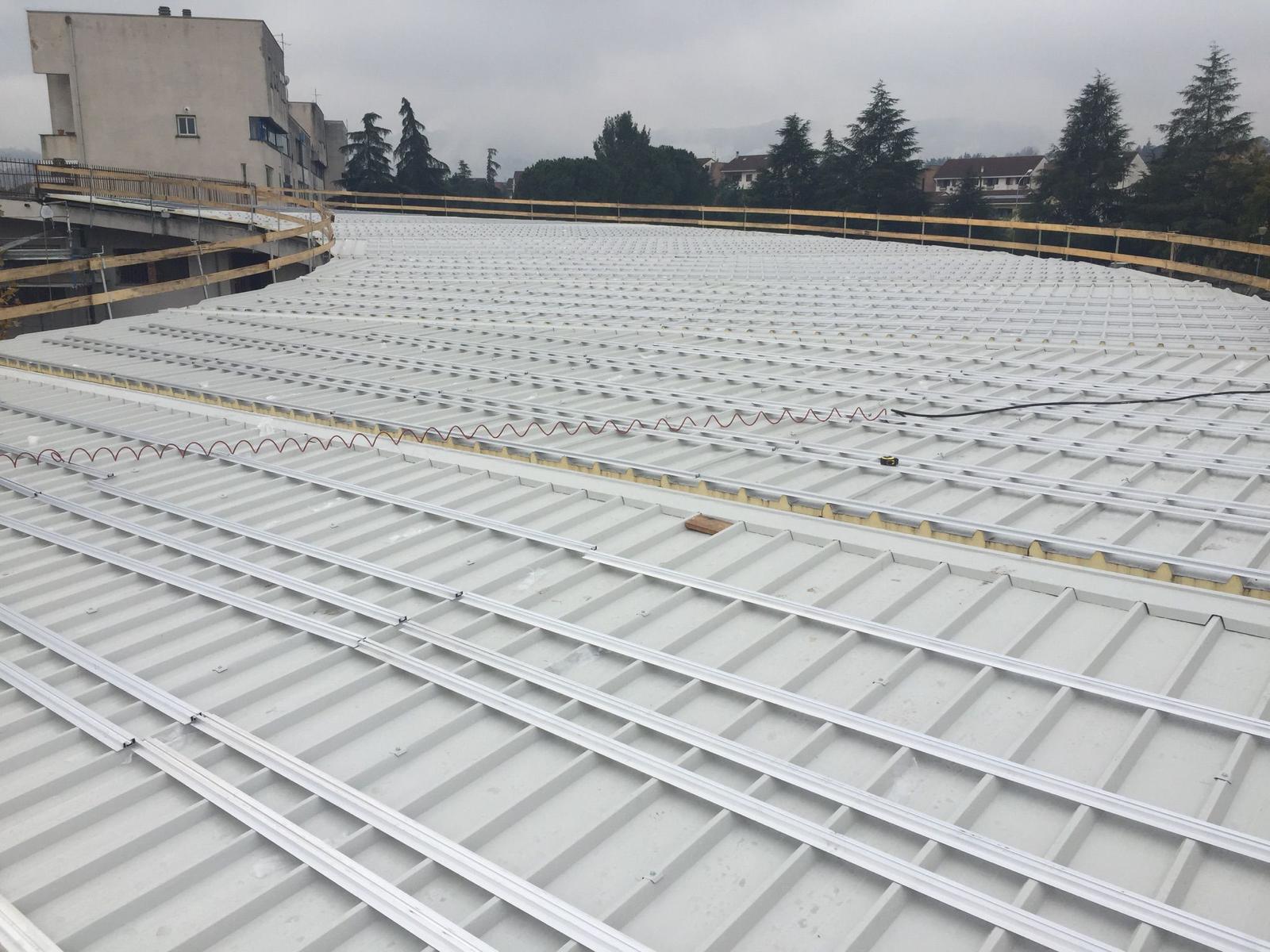 Costruzione del tetto, pannelli metallici e struttura portante con design curvo.