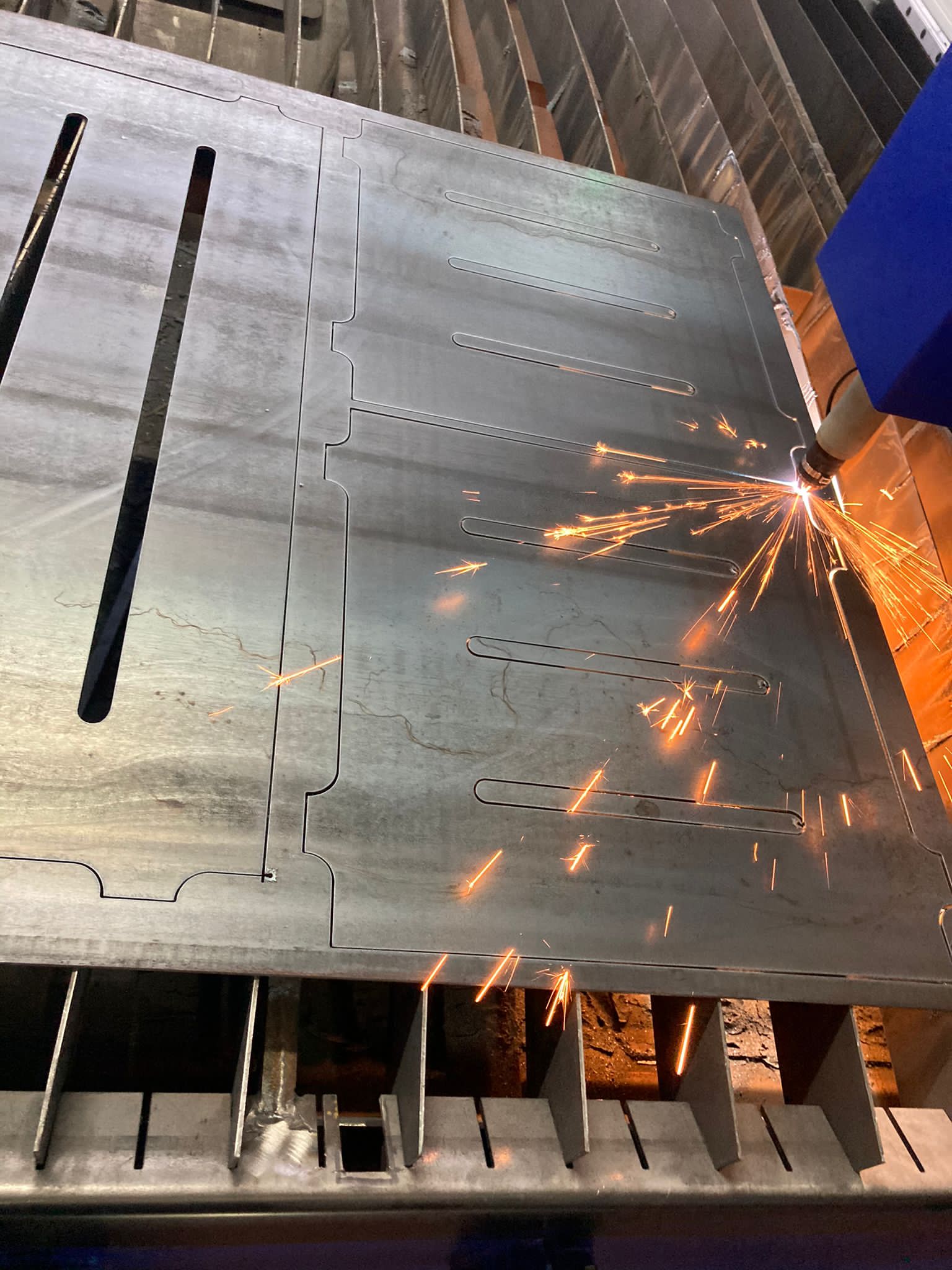 Lamiera tagliata da un taglierino al plasma, con scintille che volano.