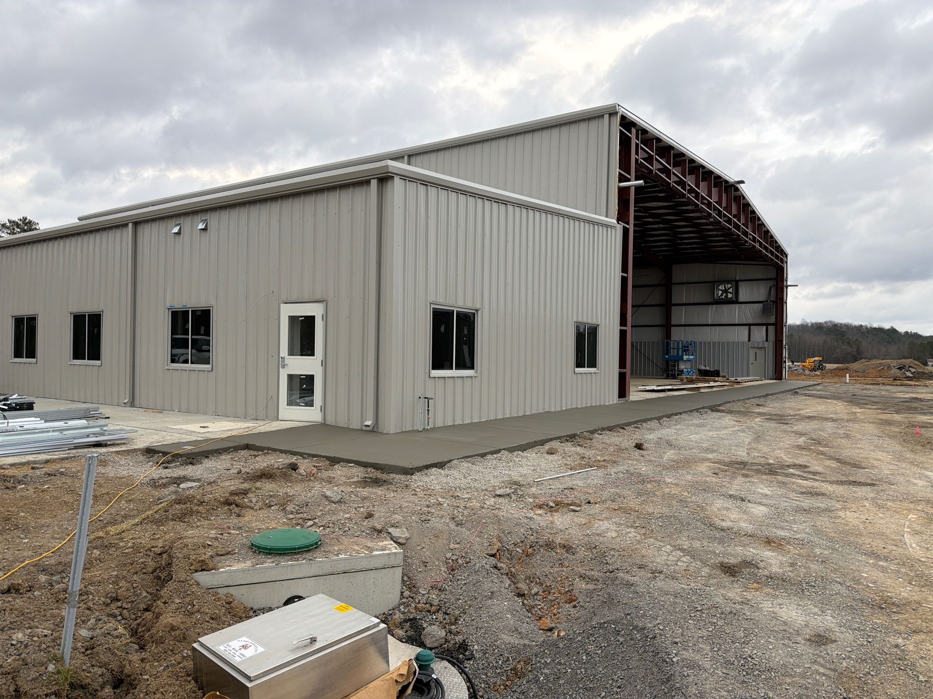 Construction workers installing a wall, using a drill, wearing safety gear.