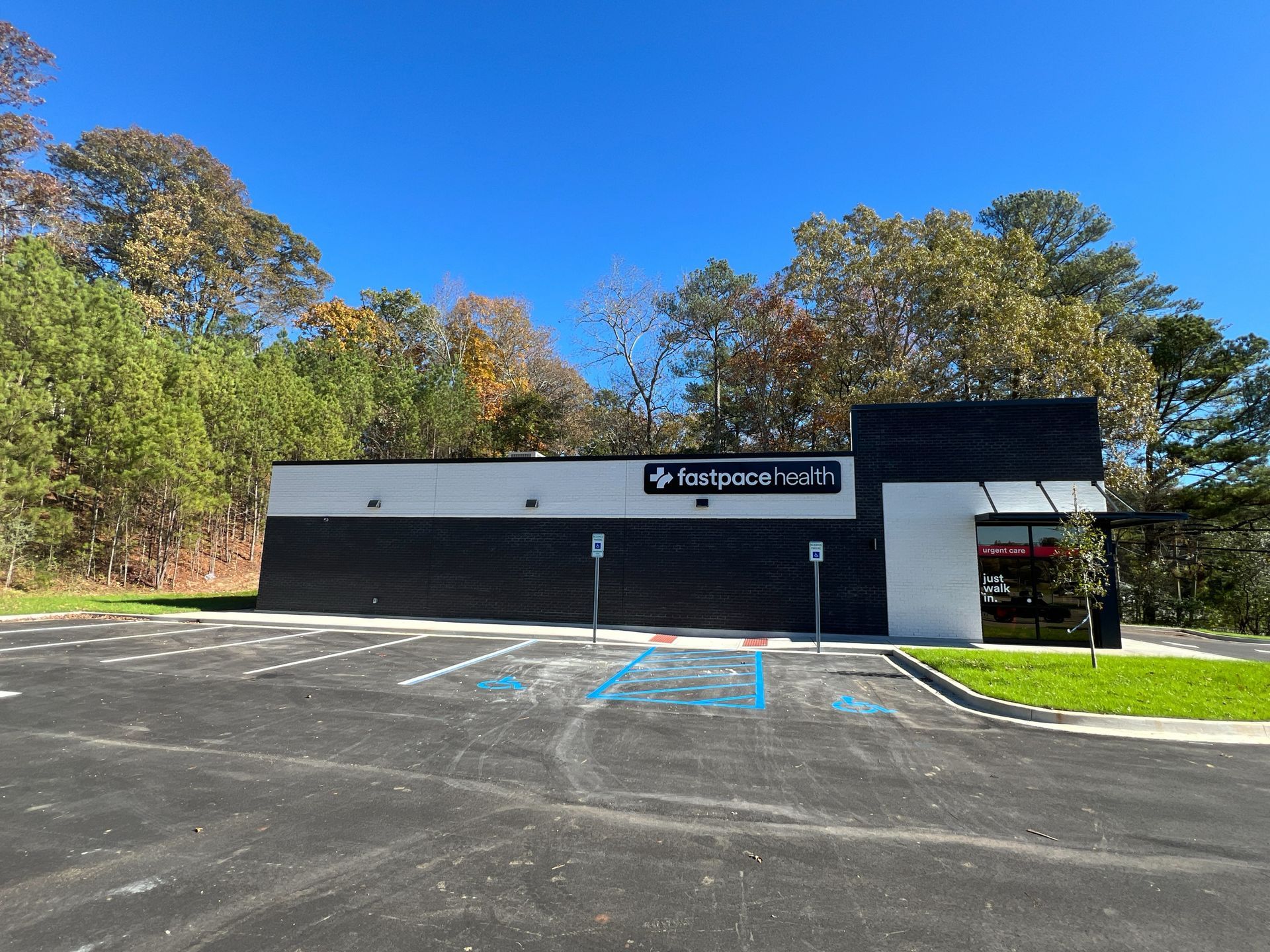 Exterior of a Tastee Freeze restaurant with black and white facade, blue parking symbols, and a blue sky.