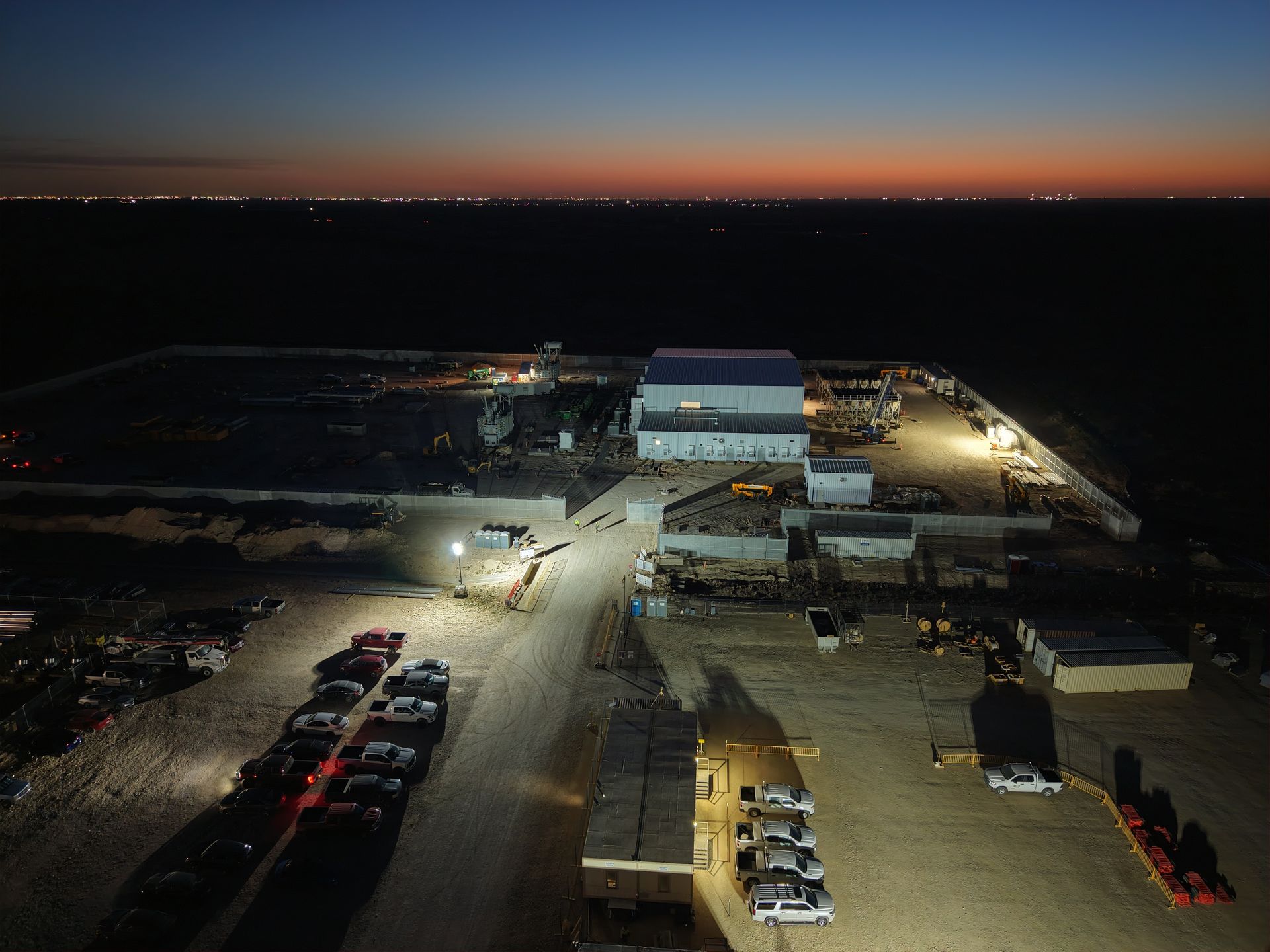 Construction site with a sign in front, under a cloudy sky.
