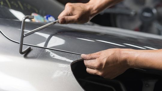 a close up of a person working on a car