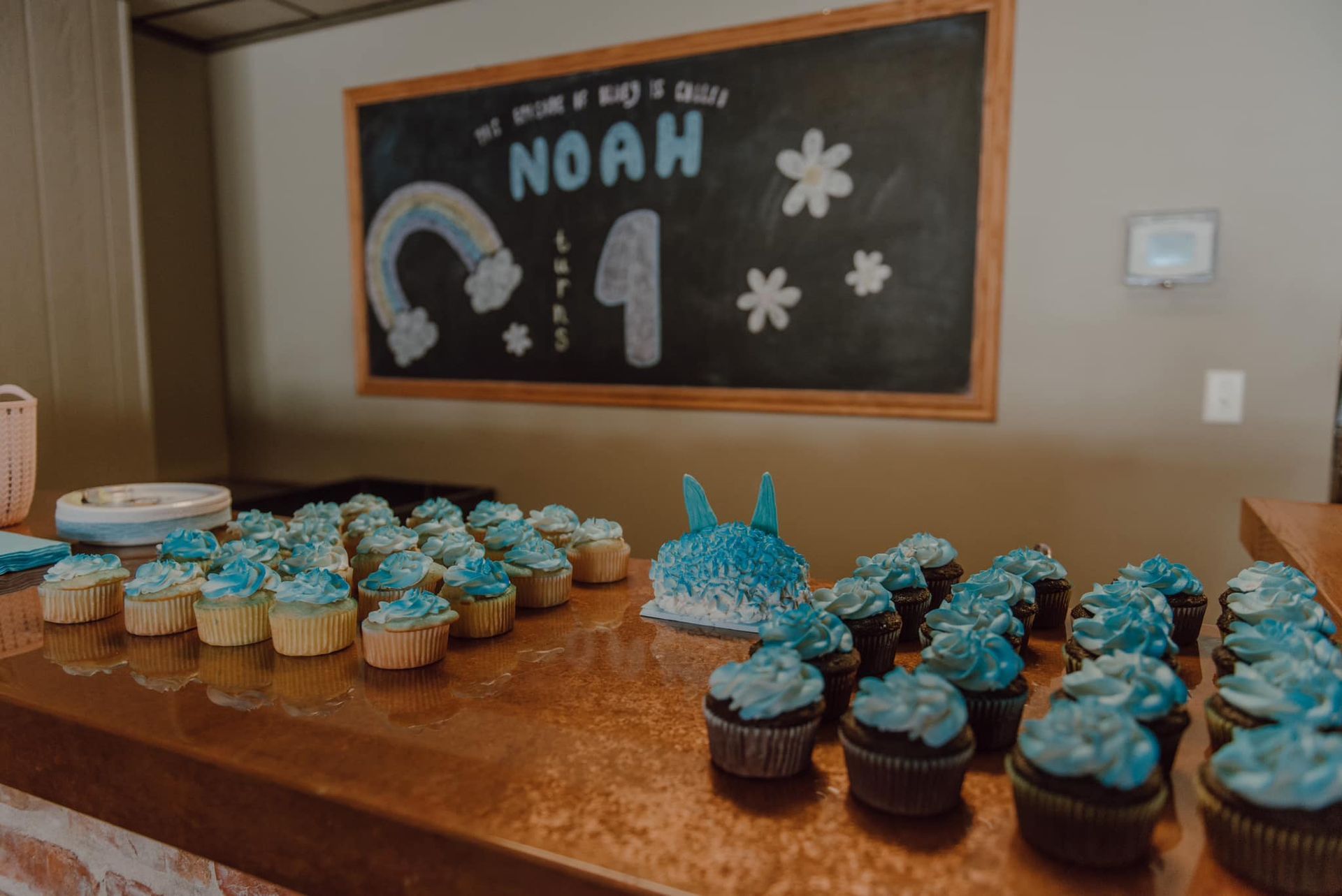 A table topped with cupcakes and a sign that says noah on it.