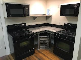 A kitchen with a stove , microwave , and refrigerator.