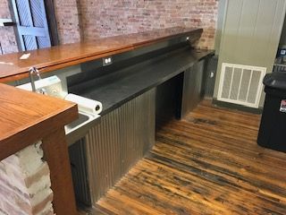 A kitchen with a sink and a wooden counter top.