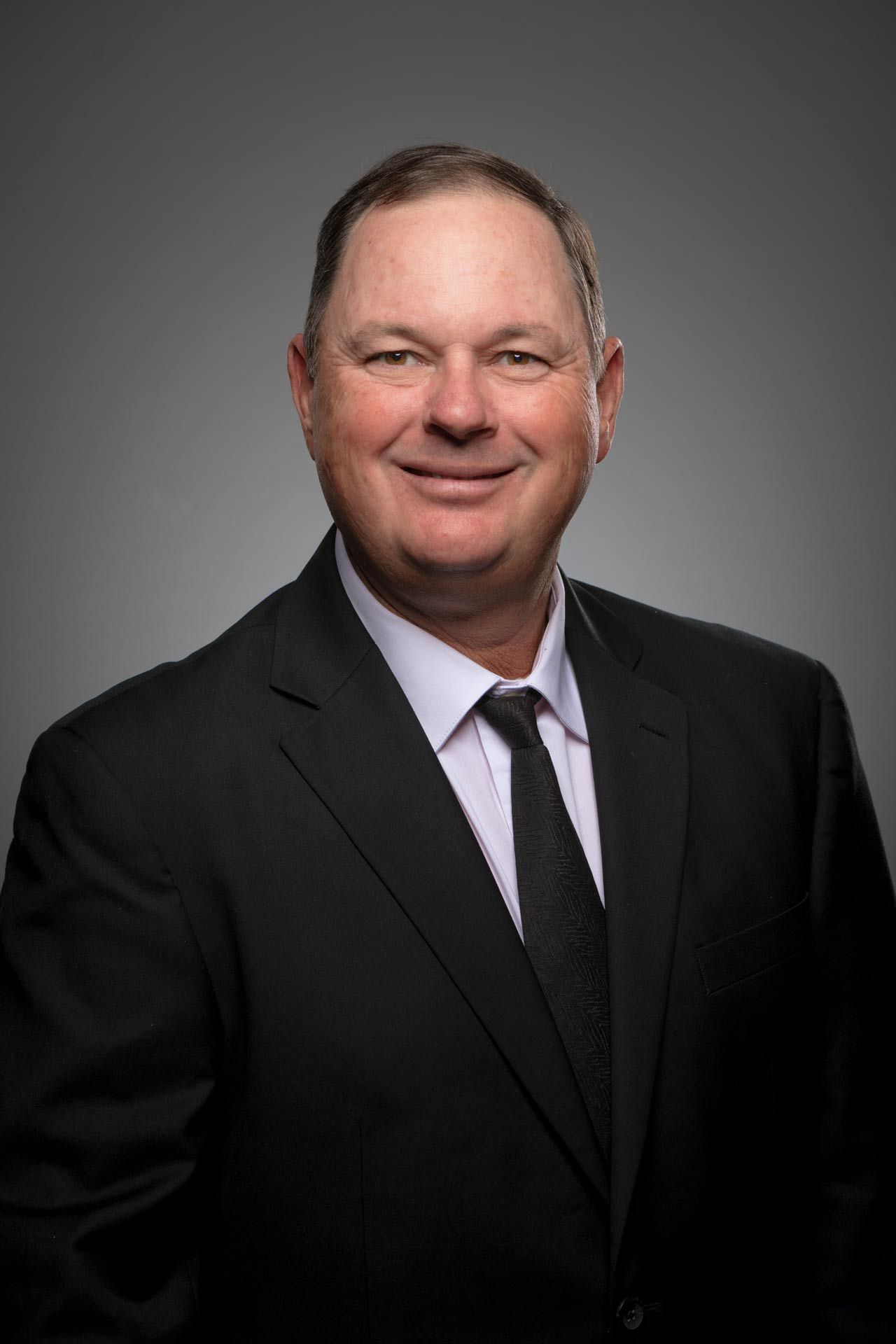 A man in a suit and tie is smiling for the camera.