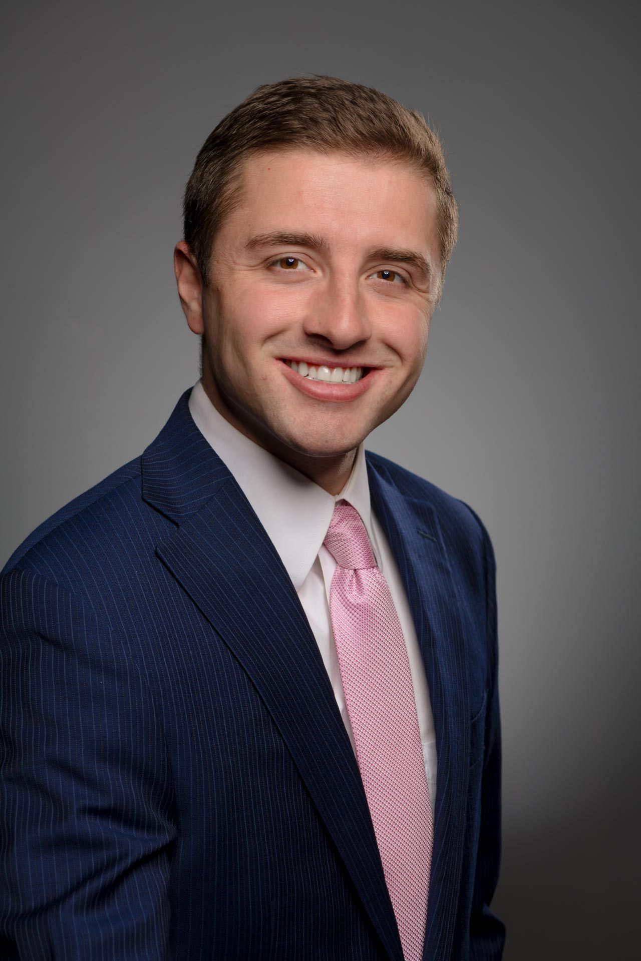 A man in a suit and tie is smiling for the camera