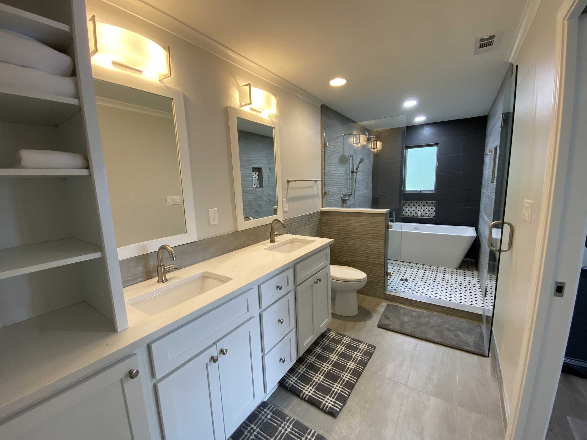 Modern bathroom with double vanity, walk-in shower, soaking tub, and storage.