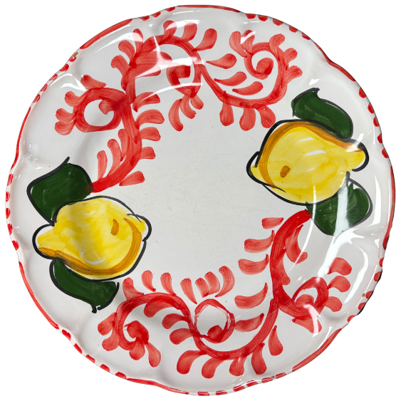 Hvit tallerken med kamskjellkant, dekorert med røde virvlede mønstre, gule sitroner og grønne blader.