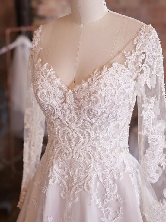 A close up of a wedding dress on a mannequin.