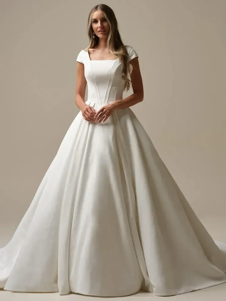 A woman is wearing a white wedding dress with short sleeves.