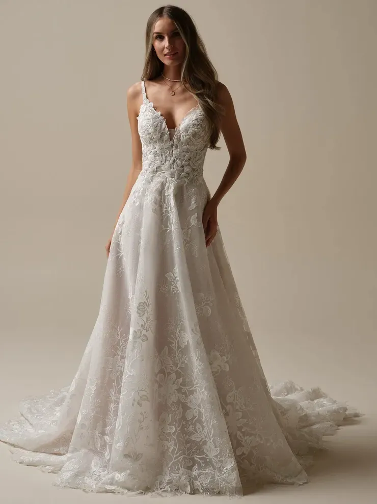 A woman is wearing a white lace wedding dress.