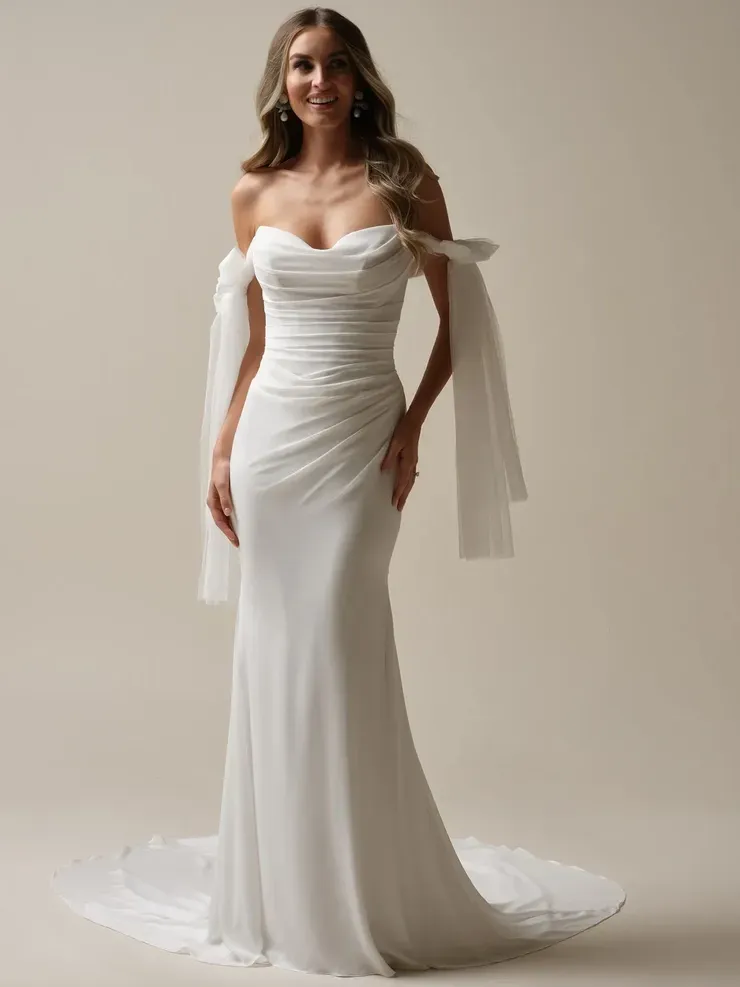 A woman is wearing a white wedding dress with off the shoulder sleeves.