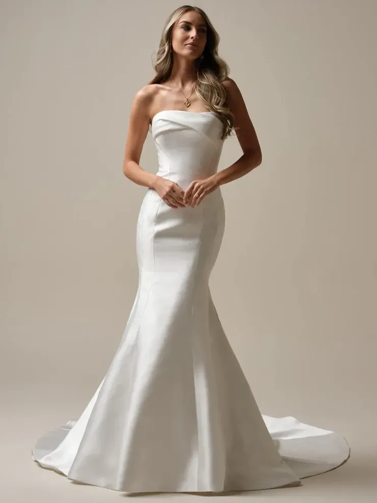 A woman is wearing a white strapless wedding dress.
