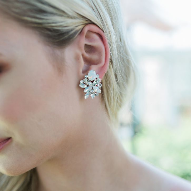 A close up of a woman wearing a pair of earrings.