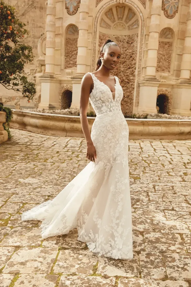 A woman in a wedding dress is standing in front of a fountain.