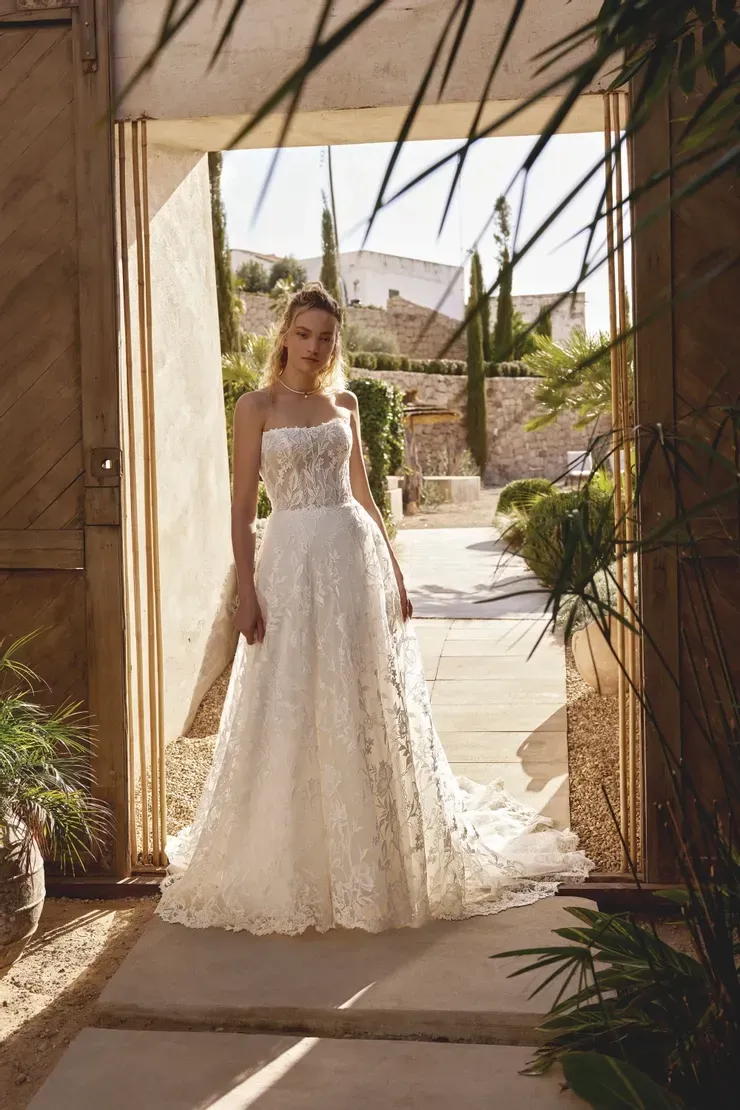 A woman in a wedding dress is standing in a doorway.