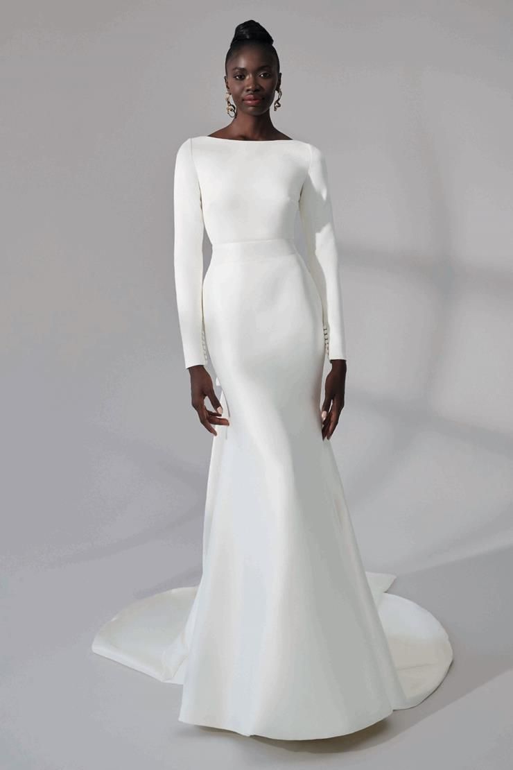 A woman is wearing a white wedding dress with long sleeves.