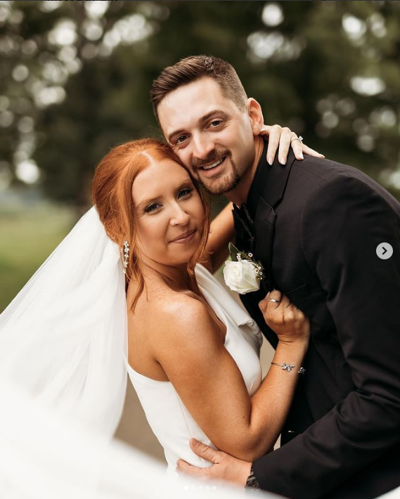 A bride and groom pose for a picture on their wedding day