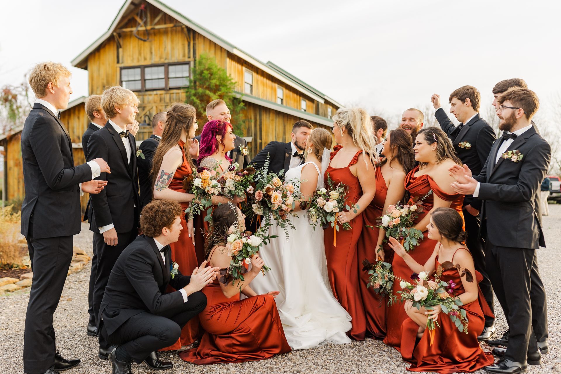 A bride and groom are posing for a picture with their wedding party.