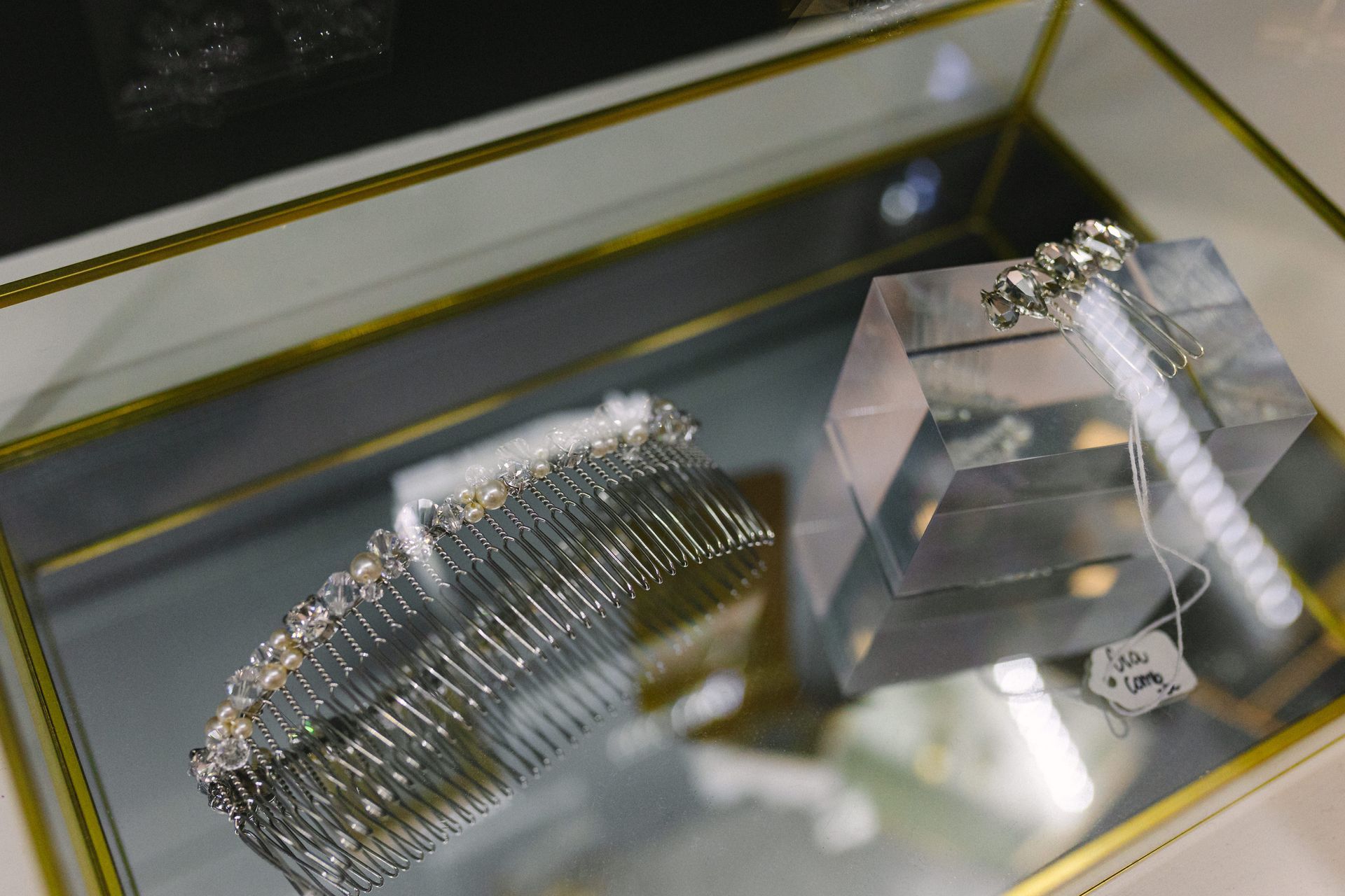 A comb and earrings are sitting on a glass display case.