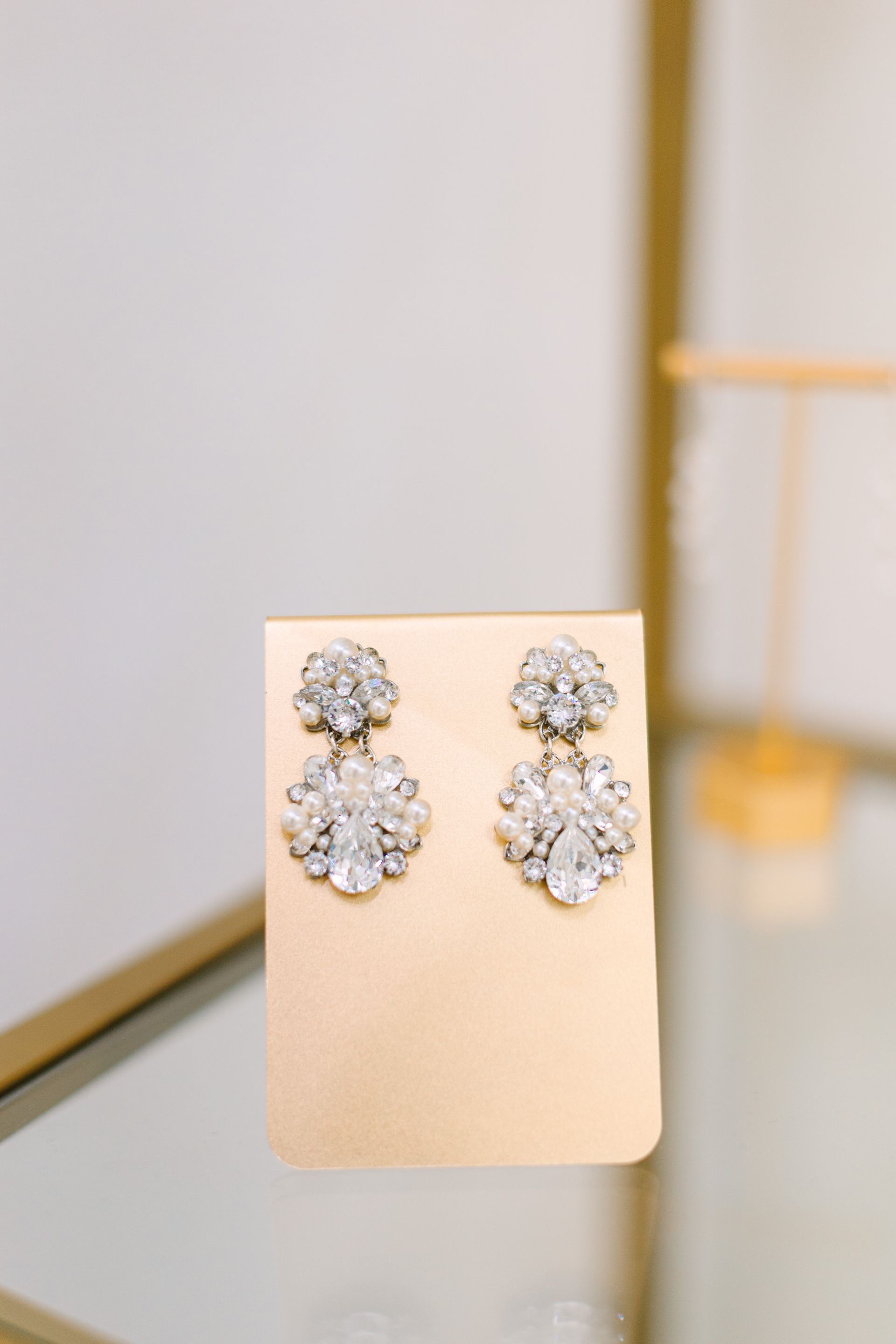 A pair of earrings are sitting on a card on a table.