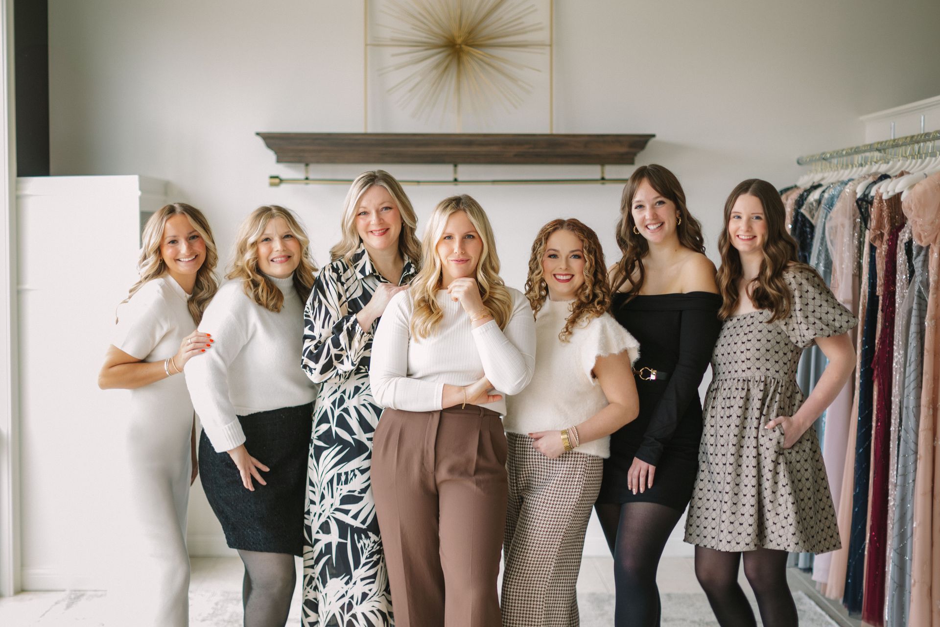 A group of women are posing for a picture in a clothing store.