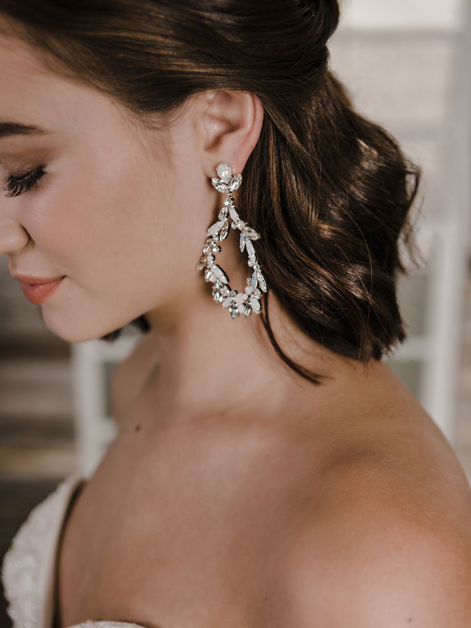 A close up of a woman wearing a pair of earrings.