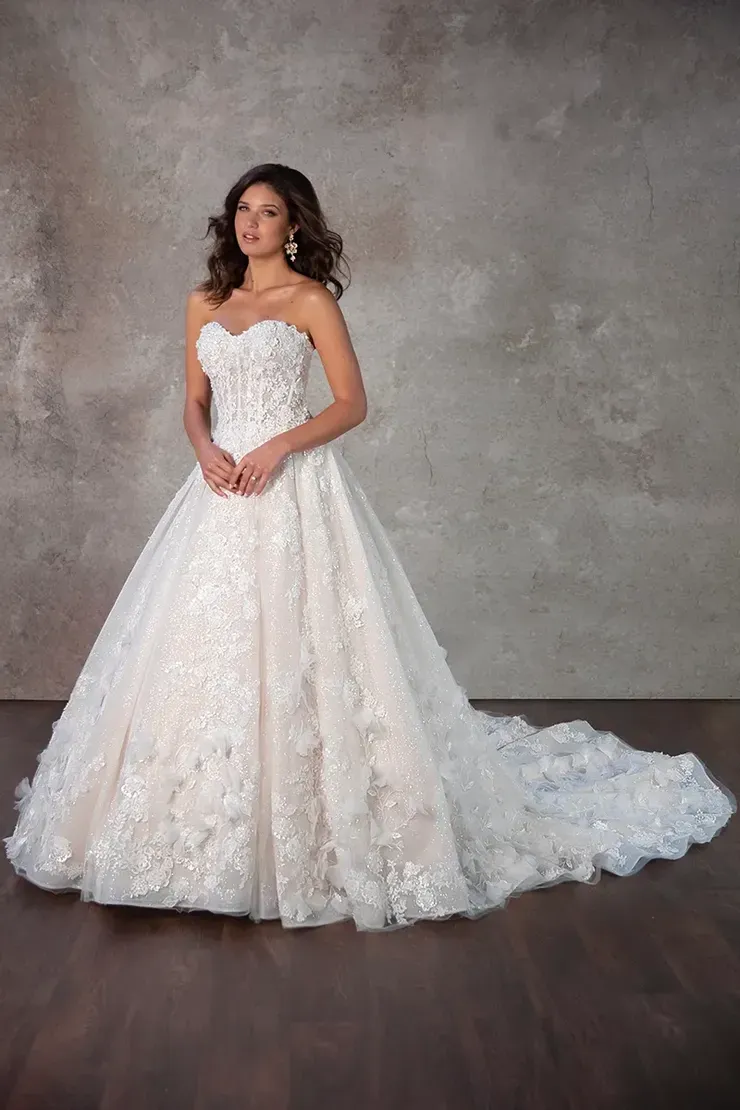 A woman in a white wedding dress is standing on a wooden floor.