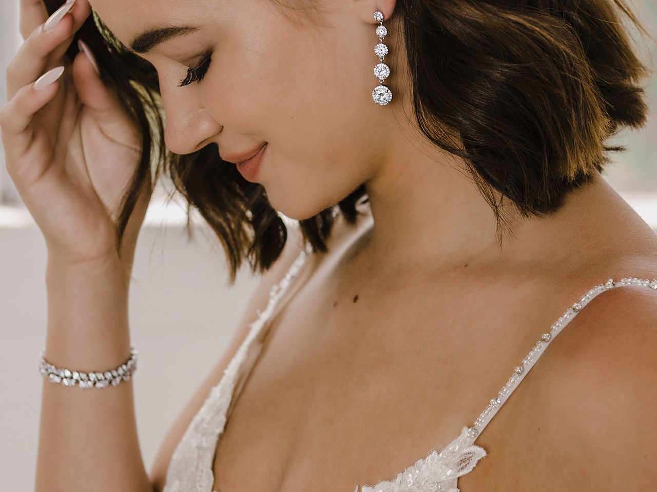 A close up of a woman wearing earrings and a bracelet
