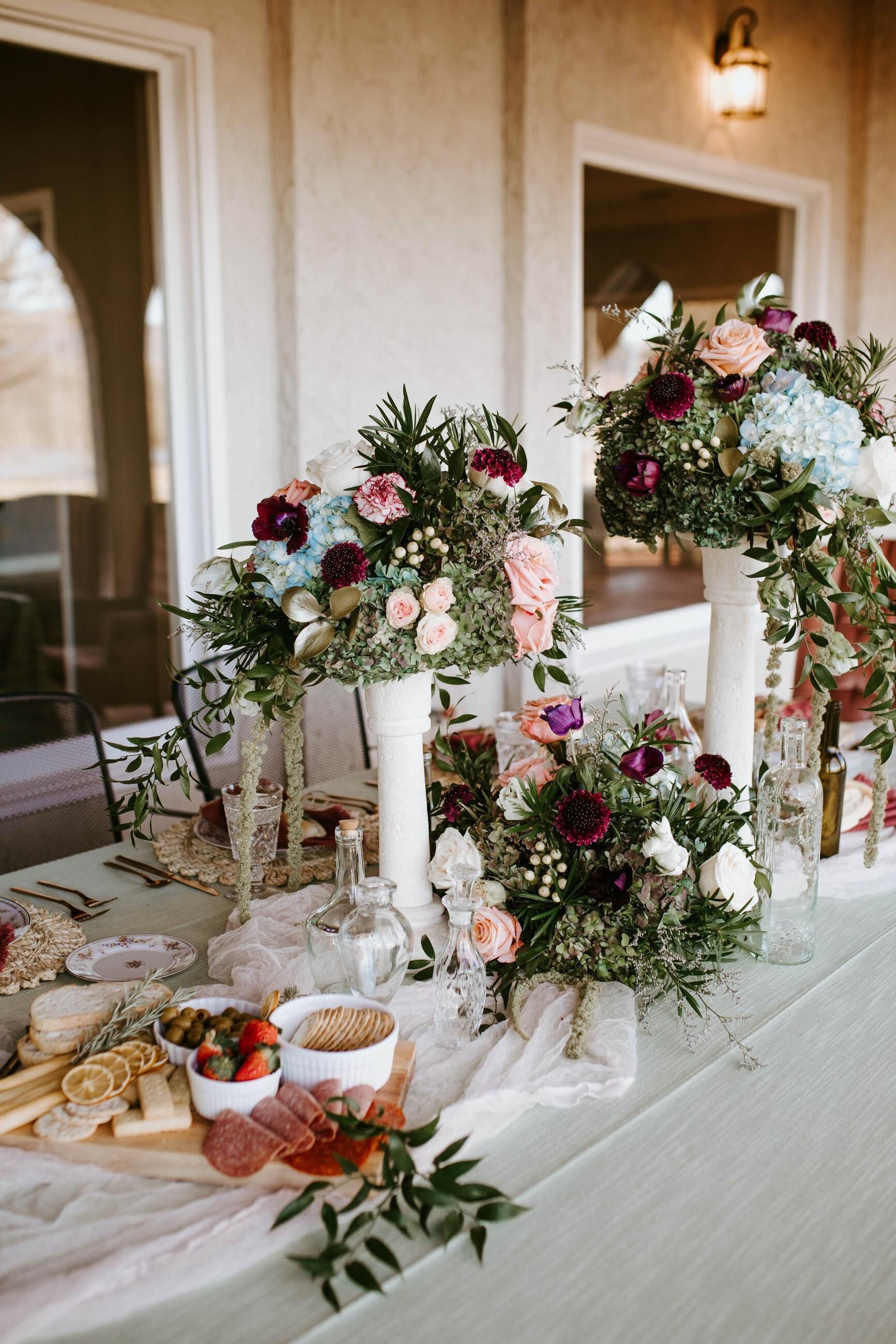 A long table with flowers in vases on it.