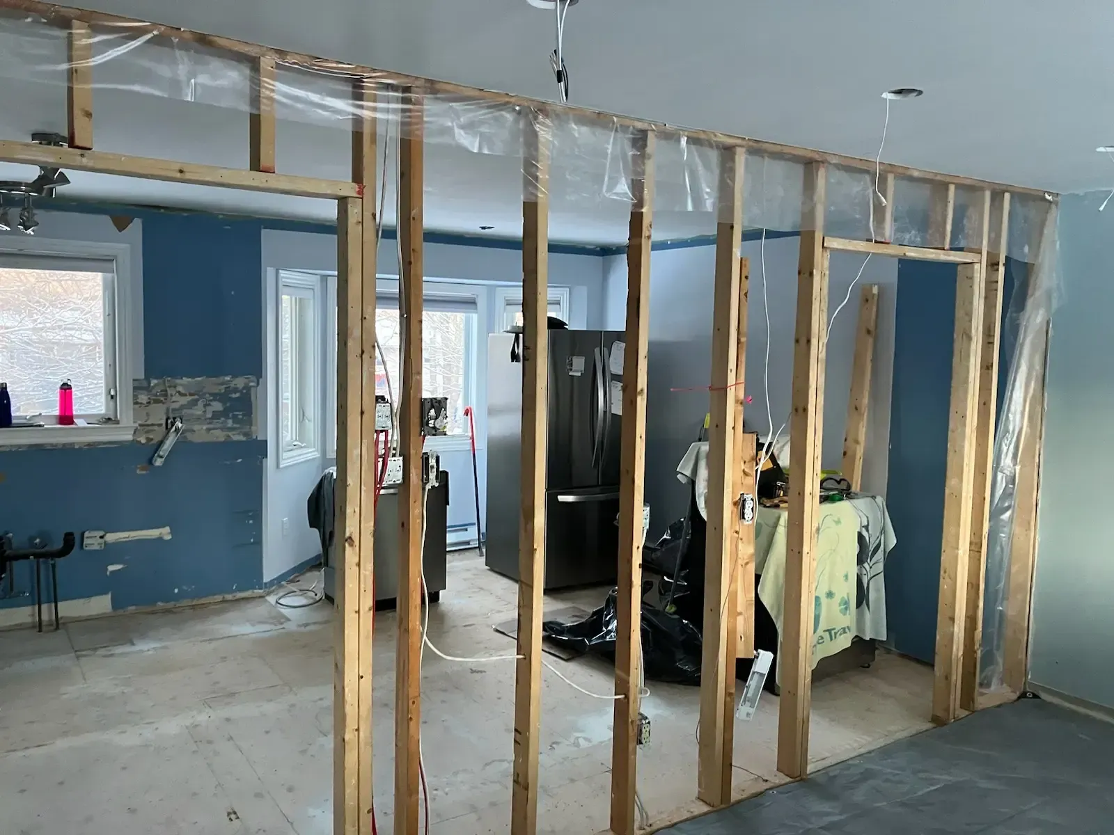 Kitchen renovation in Halifax showing wall removal and structural framing before cabinet refacing and countertop installation