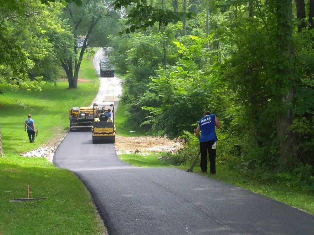 Workers working on road next to grassy area — South Concord, NC — Smith Brothers Asphalt Paving