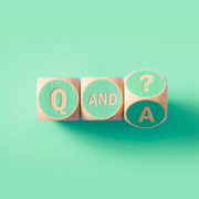 Wooden blocks spelling Q and A with a question mark, on a mint green background