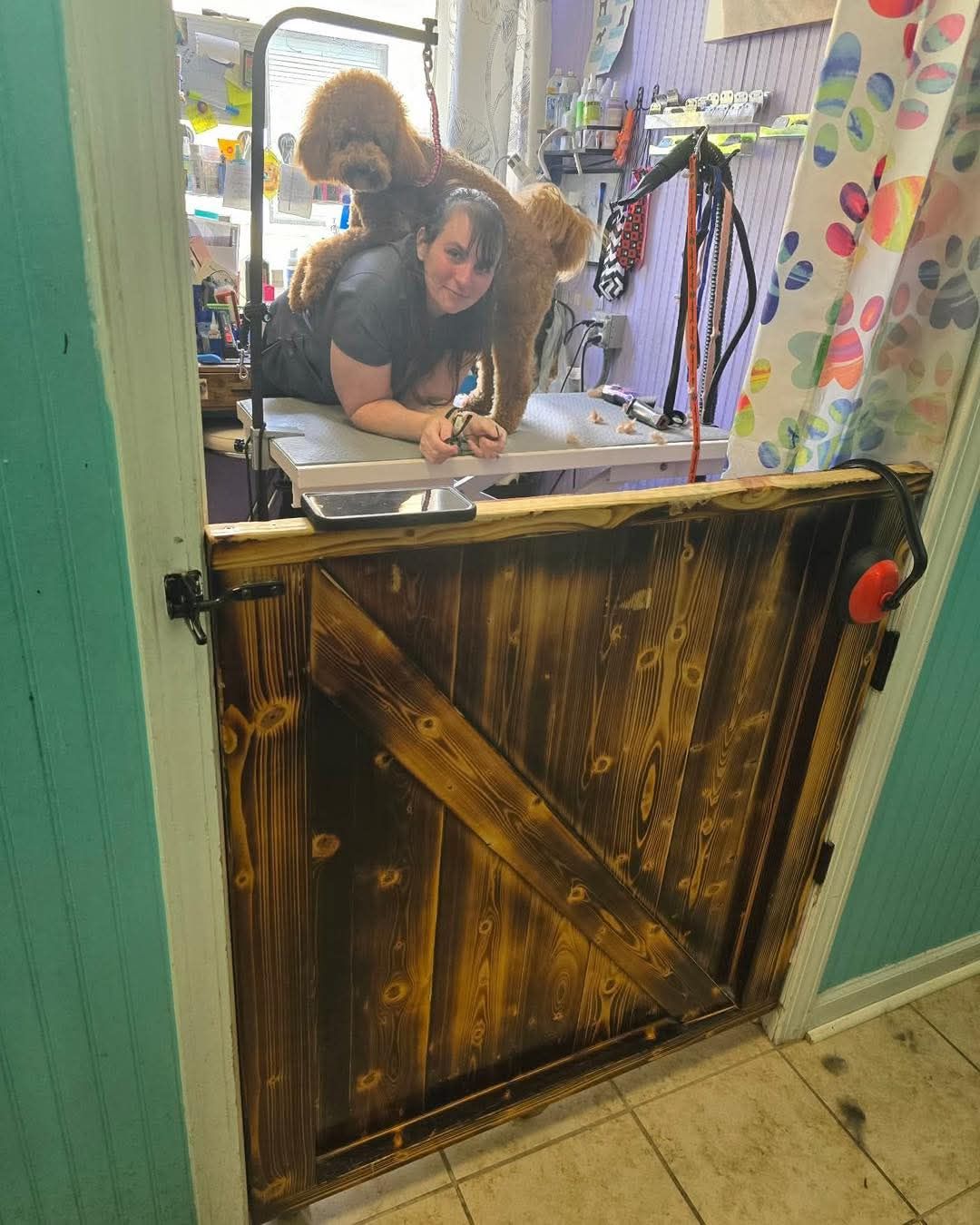 Two people leaning over a counter in a colorful shop doorway with a rustic wooden half-door.