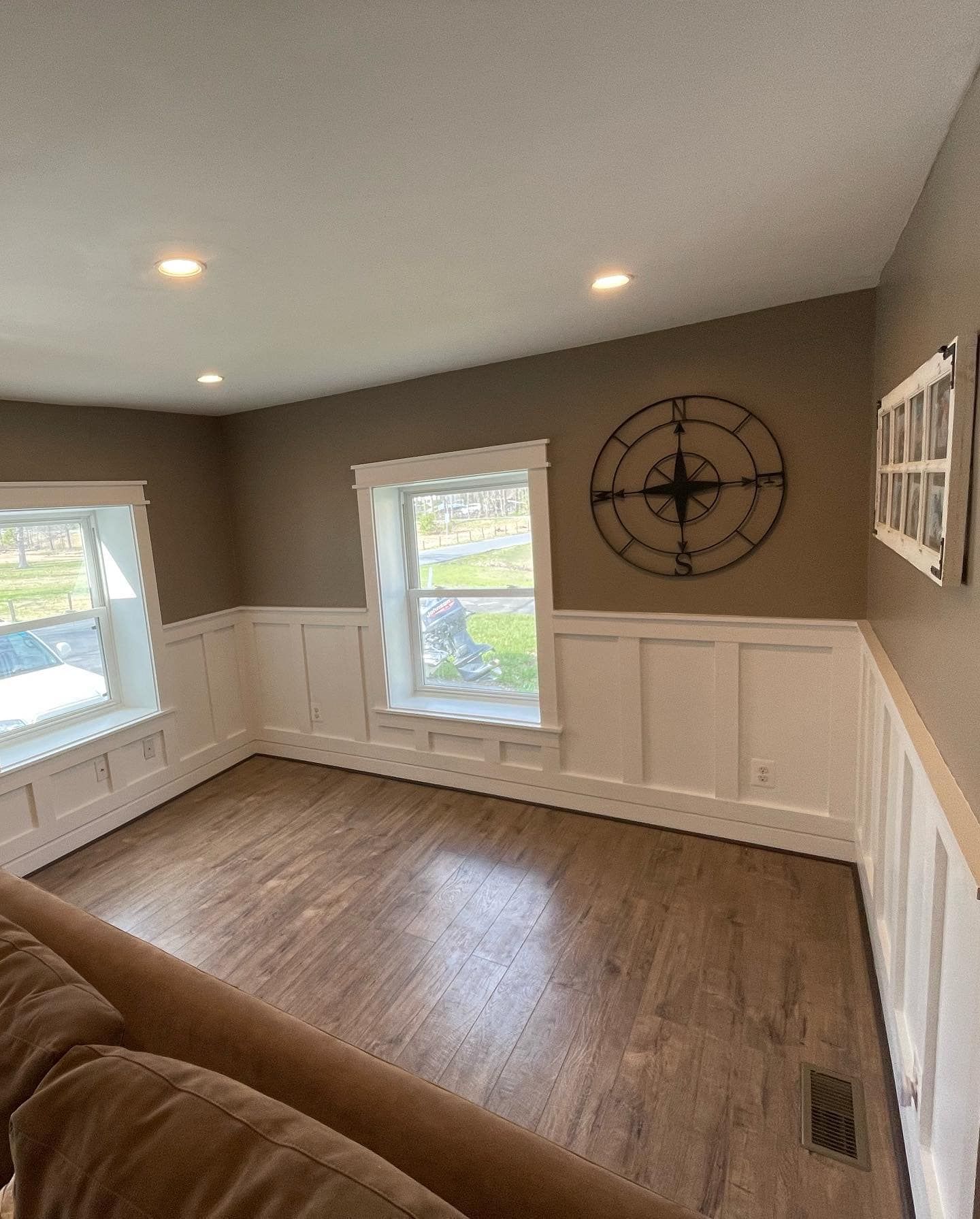 Living room with brown walls, white trim, and a large clock.