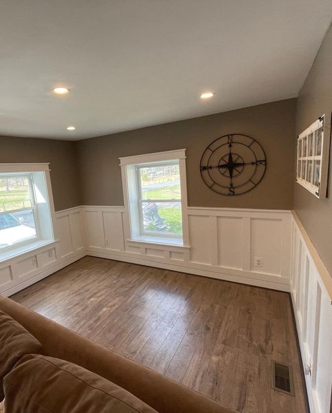 Living room with brown walls, white trim, and a large clock.