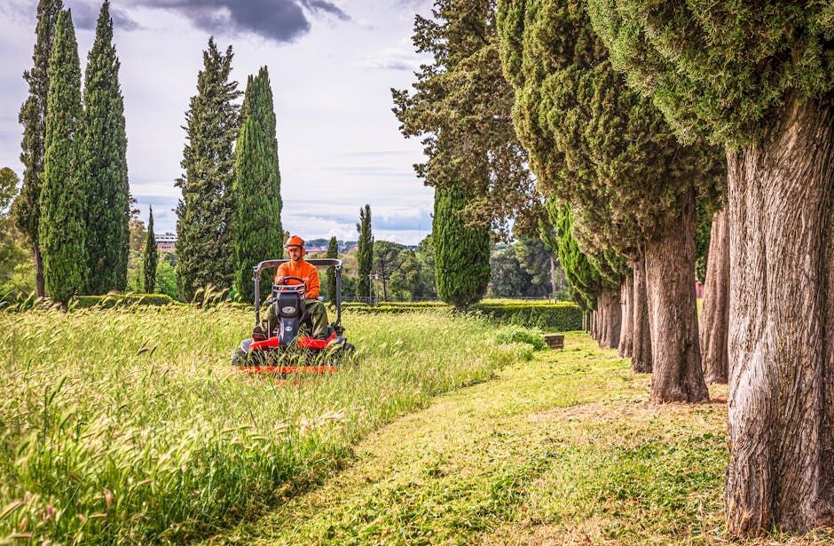 A man is riding a lawn mower through a grassy field. A man is riding a lawn mower through a grassy field.