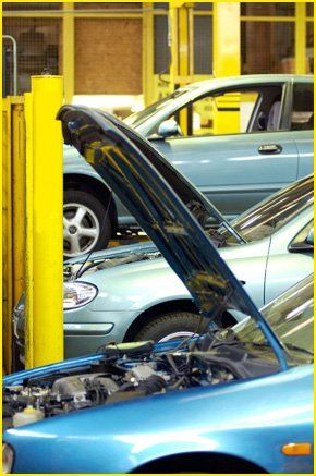 MOT testing services in London - call 020 8741 3723 Three vehicles in garage, one with bonnet open