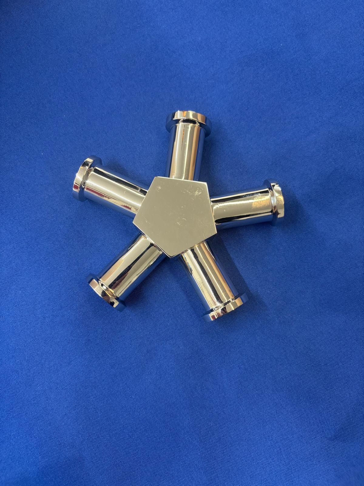 Ein Roboterarm bewegt ein Stück Metall auf einem Förderband in einer Fabrik.