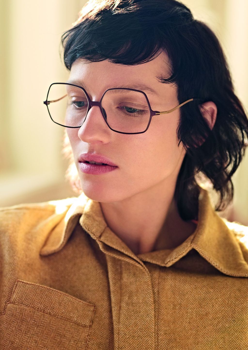 Ein weibliches Model mit einer braunen Jacke trägt eine Brille von Götti