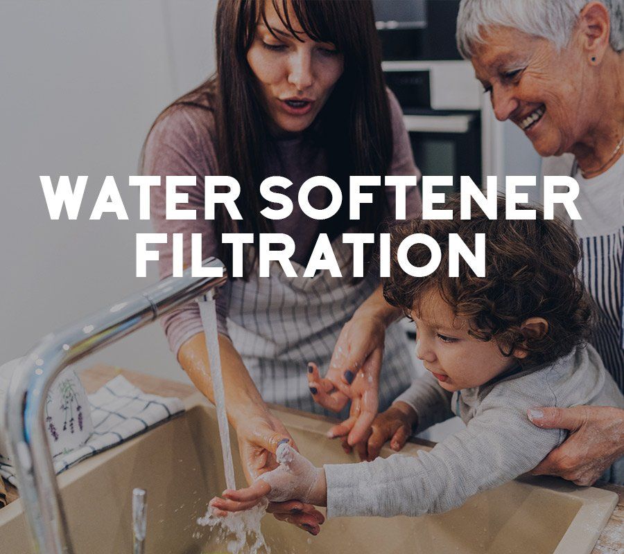 Woman and child washing hands together with an older woman looking on; kitchen.