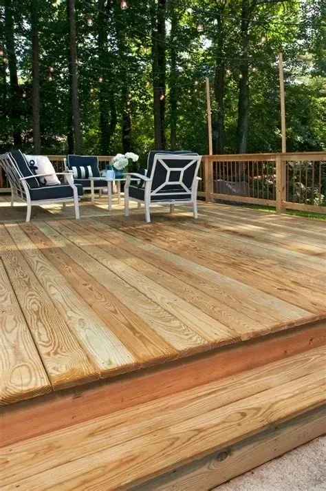 Wooden deck with outdoor furniture and surrounding trees.