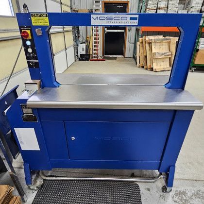 Blue mosca strapping machine in a warehouse setting