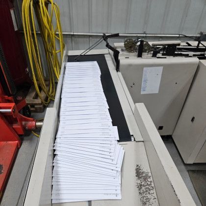 Conveyor belt with a stack of white papers