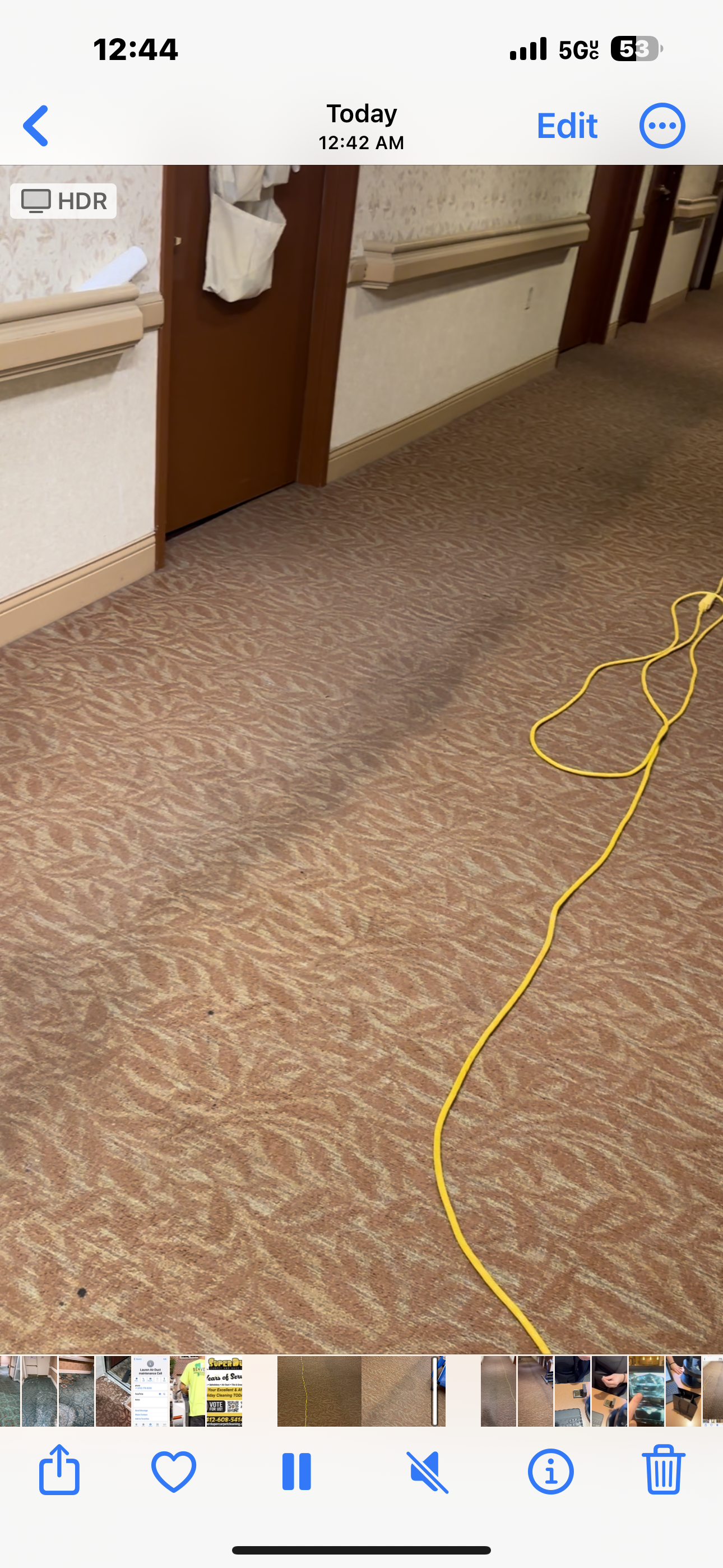Hallway with brown patterned carpet and a yellow cord running across it.