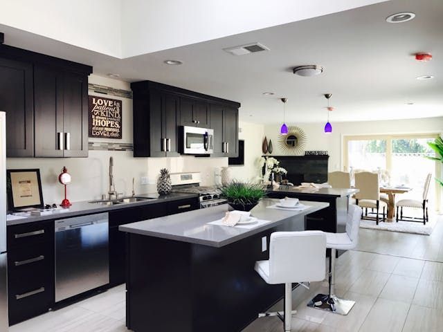 Kitchen+with+black+countertops+and+white+bar+stools.