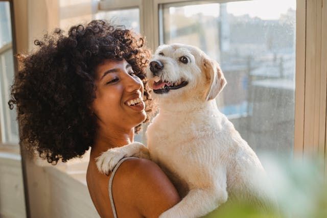 Smiling+tenant+holding+a+dog+in+arms