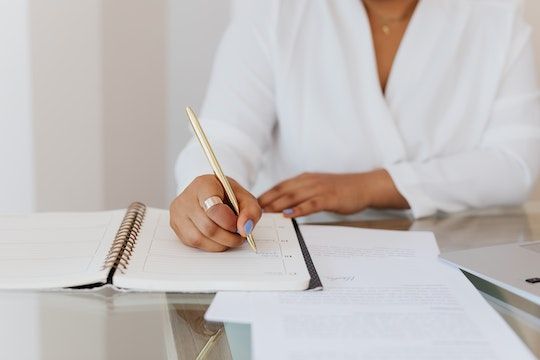 person in a white shirt looking at a contract and taking notes