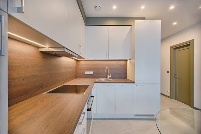 kitchen-with-white-counter-tops-wooden-cupboards-and-cream-kitchen-tiles